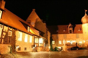 Ein traditionelles europäisches Gebäude mit einer steinernen Fassade, einer Holztreppe und einem Pflasterhof.