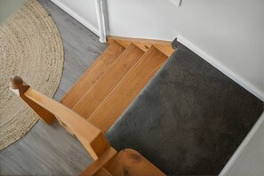 Un escalier en bois avec une plateforme recouverte de moquette.