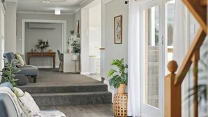 Ein Wohnzimmer mit einer Couch, einem Couchtisch und einer Treppe, die in einen oberen Bereich führt.