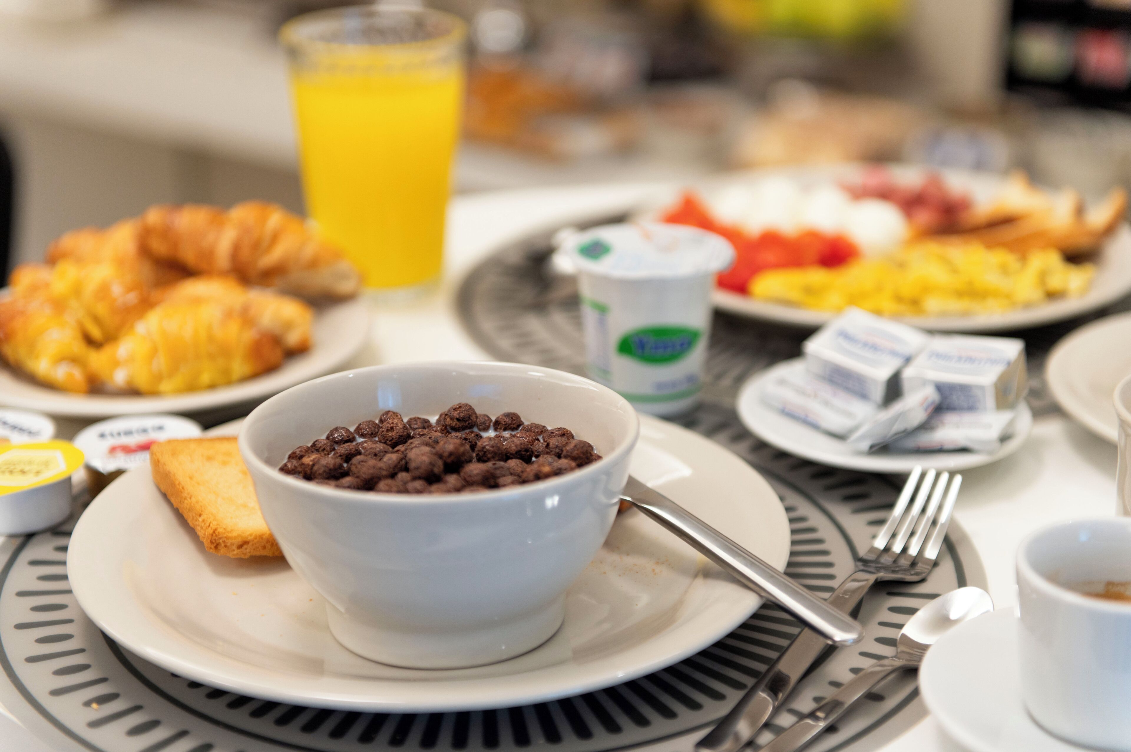 Esmorzar amb croissants, cereals i un got de suc d'aranja.