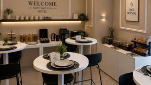 Un moderno vestíbulo de hotel con mostrador de recepción, zona de estar y bufé.