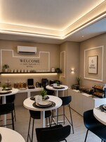 Een moderne hotel lobby met een receptiebalie, een zithoek en een buffet.