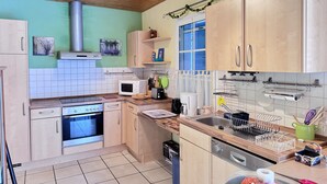 Eine Küche mit Holzschränken, einer Mikrowelle, einem Backofen und einem Spülbecken.