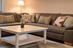 Ein Wohnzimmer mit einer Couch, einem Couchtisch und einer Lampe.