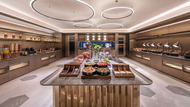 A modern kitchen with a central island, built-in appliances, and a variety of food items displayed. - Crystal Hotel Qingdao Liaoyang West Road (Qingdao)