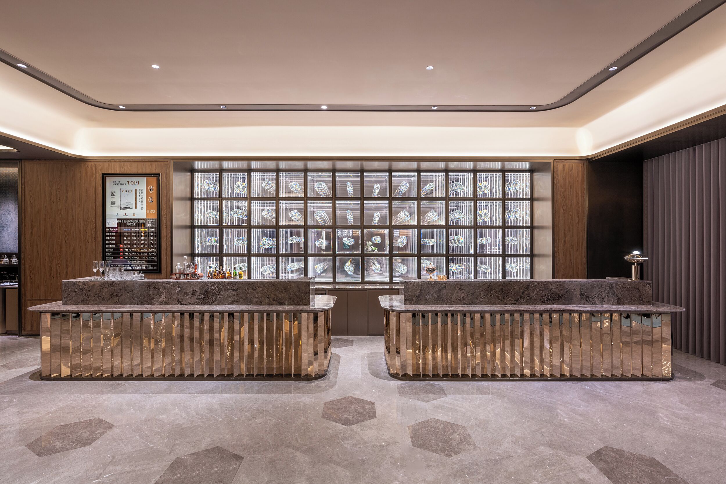 Un área de recepción con mostrador de mármol, una pared decorada con objetos enmarcados y un panel de madera.
