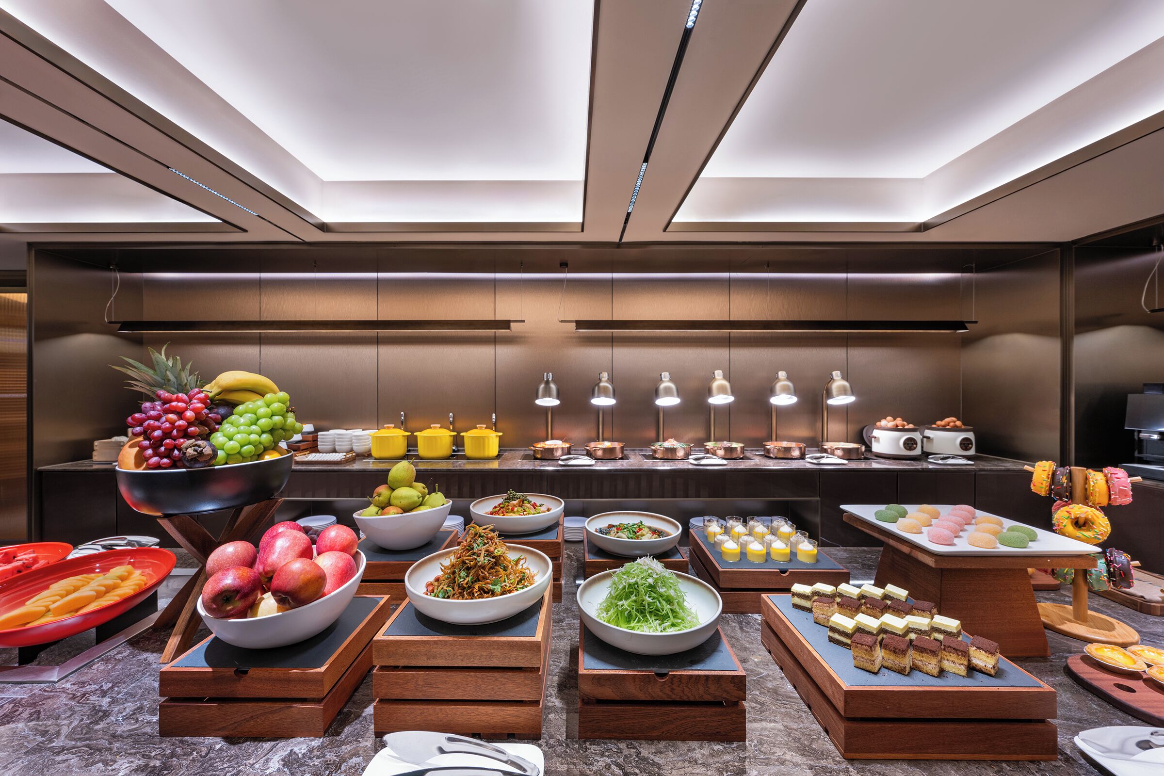 Un bufé con diversos alimentos y un diseño interior moderno.