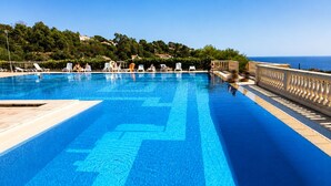 A clear blue pool with a view of the sea, surrounded by lounge chairs and a balustrade. - Cosy studio, magnificent swimming pool with exceptional view of the Gulf of St-Tropez (Roquebrune-sur-Argens)