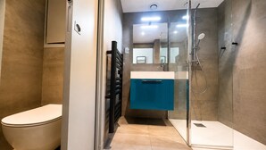 A modern bathroom with a toilet, a shower, and a sink. - Cosy studio, magnificent swimming pool with exceptional view of the Gulf of St-Tropez (Roquebrune-sur-Argens)