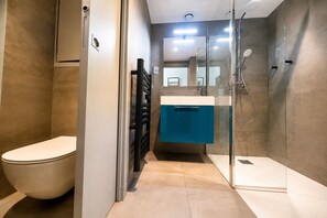 A modern bathroom with a toilet, a shower, and a sink. - Cosy studio, magnificent swimming pool with exceptional view of the Gulf of St-Tropez (Roquebrune-sur-Argens)