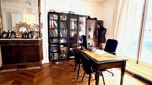 A room with a wooden herringbone floor, a large mirror, a bookshelf, and a desk with chairs. - Champs Elysées  190 m2 - 8 personnes -Exceptionnel Appartement Haussmannien (Paris)