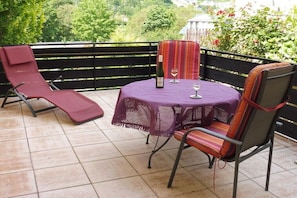 A patio with a table, chairs, and a bottle of wine. - Holiday apartment with 2 bedrooms (Enkirch)