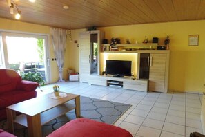A living room with a TV, sofa, and coffee table. - Holiday apartment with 2 bedrooms (Enkirch)