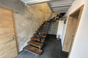 Eine Treppe mit Holzboden und Metallgeländern, die zu einer oberen Etage führt.