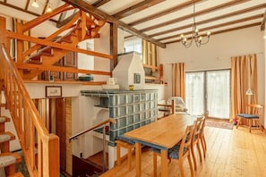 A wooden staircase leading to a dining area with a table and chairs, a built-in stove, and a chandelier.