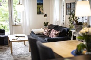 Een moderne woonkamer met een bank, een salontafel en een lamp.