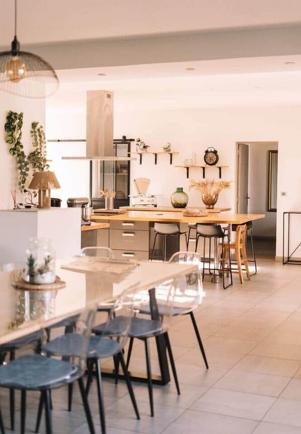 Une cuisine moderne dotée d’un îlot central, de tabourets de bar et d’une table à manger avec des chaises.