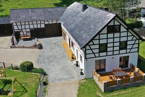 Ein traditionelles Fachwerkhäuschen mit einem Stehendach, einem Innenhof und einer kleinen Außen-Sitzgelegenheit.