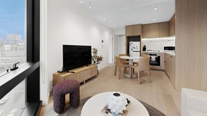 Un apartamento moderno con televisor grande, comedor, cocina y vistas a la ciudad.