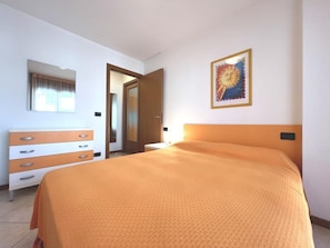 Ein Hotelzimmer mit einem Bett, einem Schminktisch, einem Spiegel und einem Wandbild.