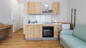 A compact kitchen with wooden cabinets, a built-in oven, and a dishwasher. - GuestHost - Cozy Balcony Flat X3 near the Sea (Francavilla al Mare)