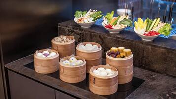A buffet with various food items and bamboo steamers.