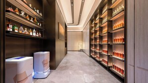 Un pasillo con estantes llenos de botellas de licores, un dispensador de agua y un diseño interior moderno.