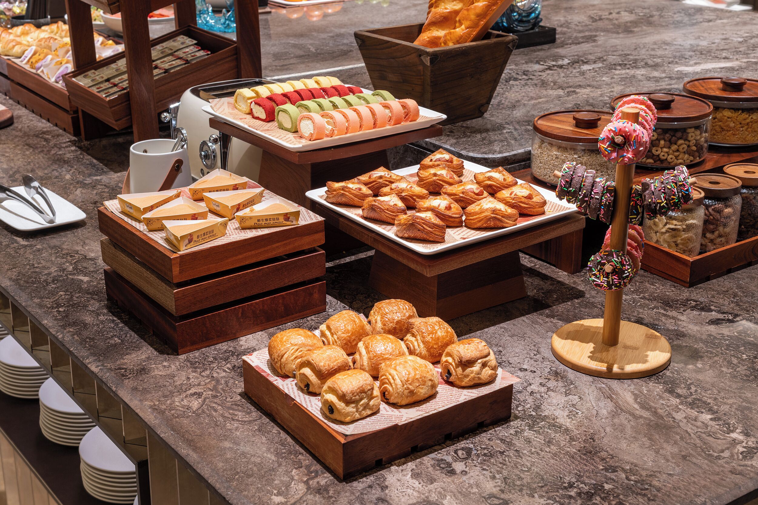 A variety of pastries and baked goods displayed on a marble countertop.