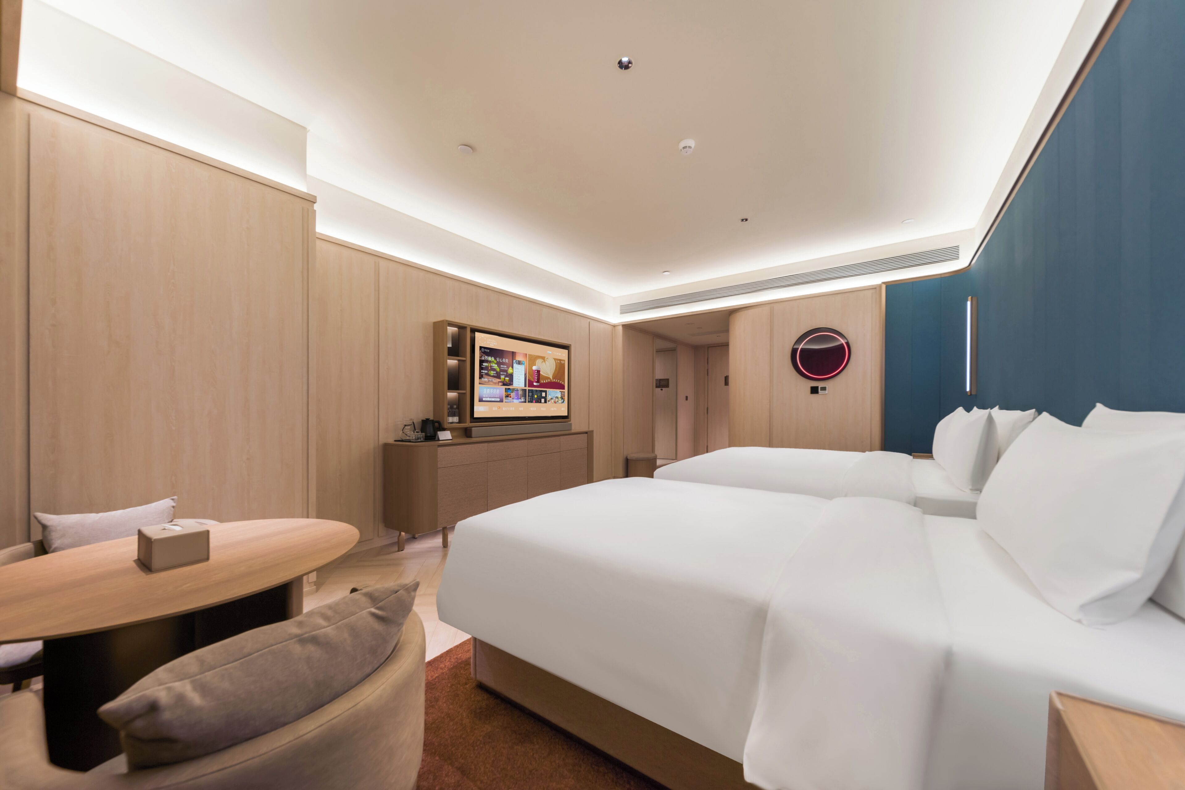 A modern hotel room with a large bed, a desk, and a television.