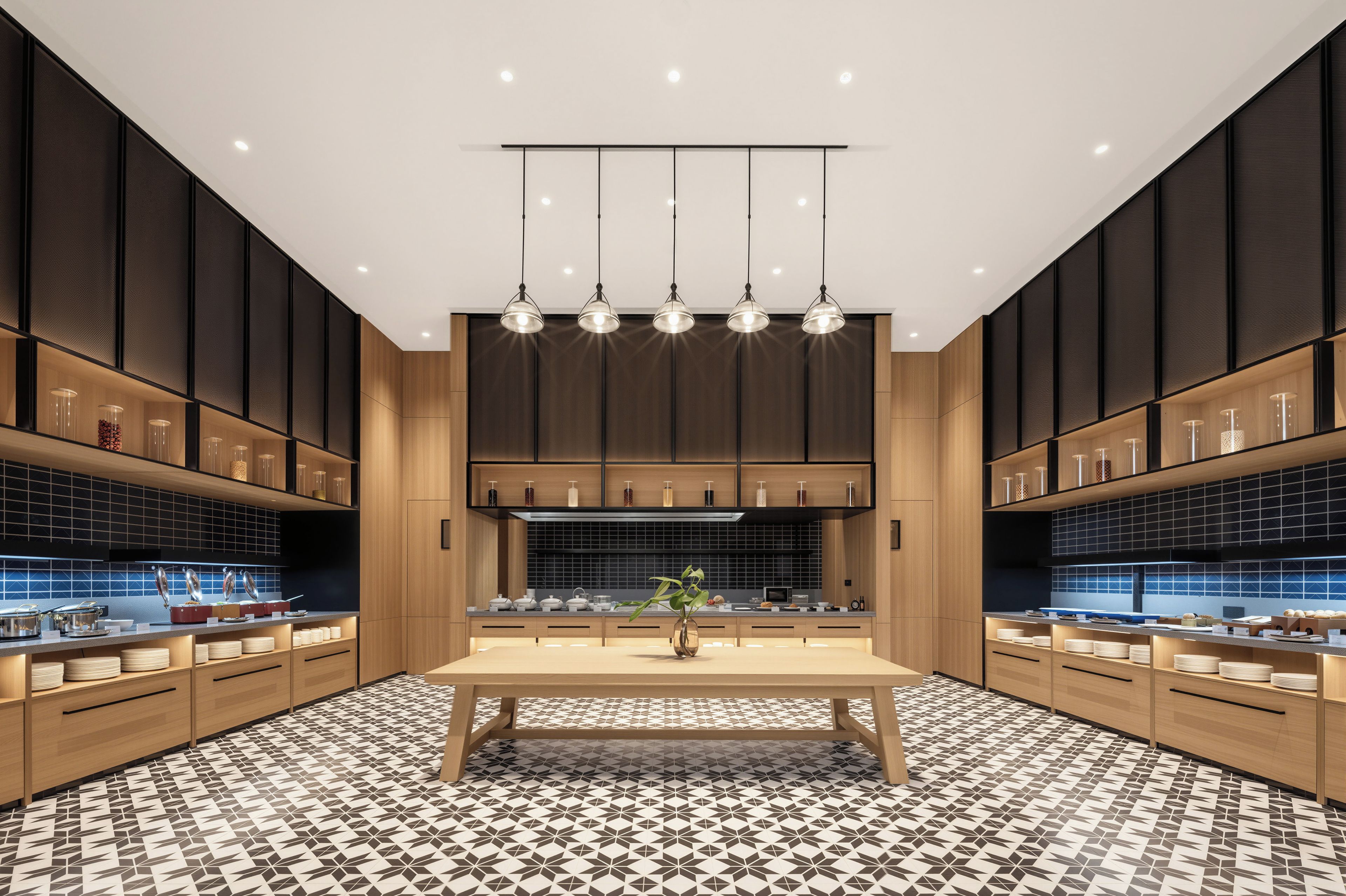 A modern kitchen with a central island, pendant lighting, and a patterned floor.
