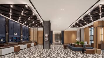 A modern lobby with a geometric patterned floor, a central pillar, and seating areas.