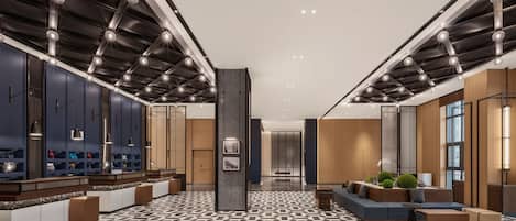 A modern lobby with a geometric patterned floor, a central pillar, and seating areas.
