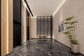 A modern interior with a marble floor, a bench, a potted plant, and framed artwork on the wall. - Four Points by Sheraton Yinchuan Xingqing (Yinchuan)