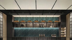 A modern bar area with a herringbone tile backsplash, built-in shelves, and a checkered floor pattern.