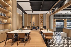 A modern restaurant interior with wooden paneling, multiple dining tables, and a patterned floor. - Four Points by Sheraton Yinchuan Xingqing (Yinchuan)