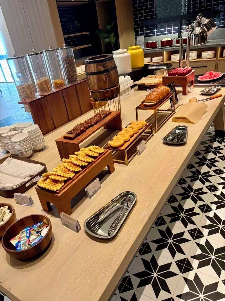 A buffet setup with various food items, serving utensils, and containers.