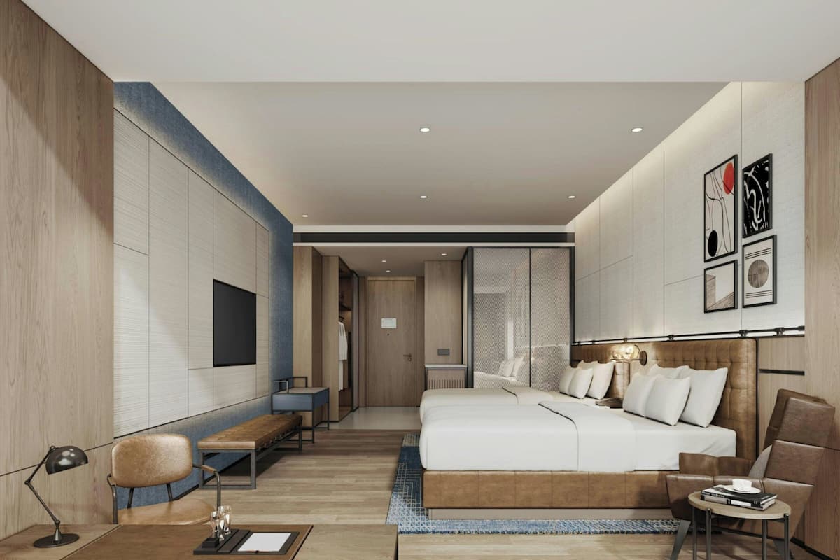 Una habitación de hotel moderna con una cama grande, un escritorio, una silla y un sofá.