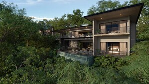 Una casa moderna de varios pisos con piscina, rodeada de abundante vegetación.