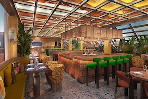 A restaurant with a high ceiling, a bar area, and outdoor seating.