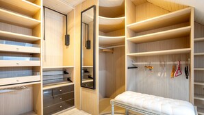 A walk-in closet with multiple shelves, drawers, and hanging space.
