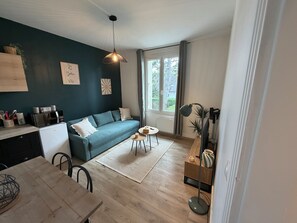 Un salon moderne comprenant un canapé, une table à manger et un coin cuisine.