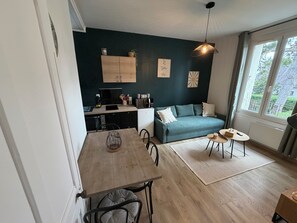 Un espace de vie compact comprenant un coin cuisine, une table Ă manger, un canapĂ© et une fenĂȘtre avec vue.