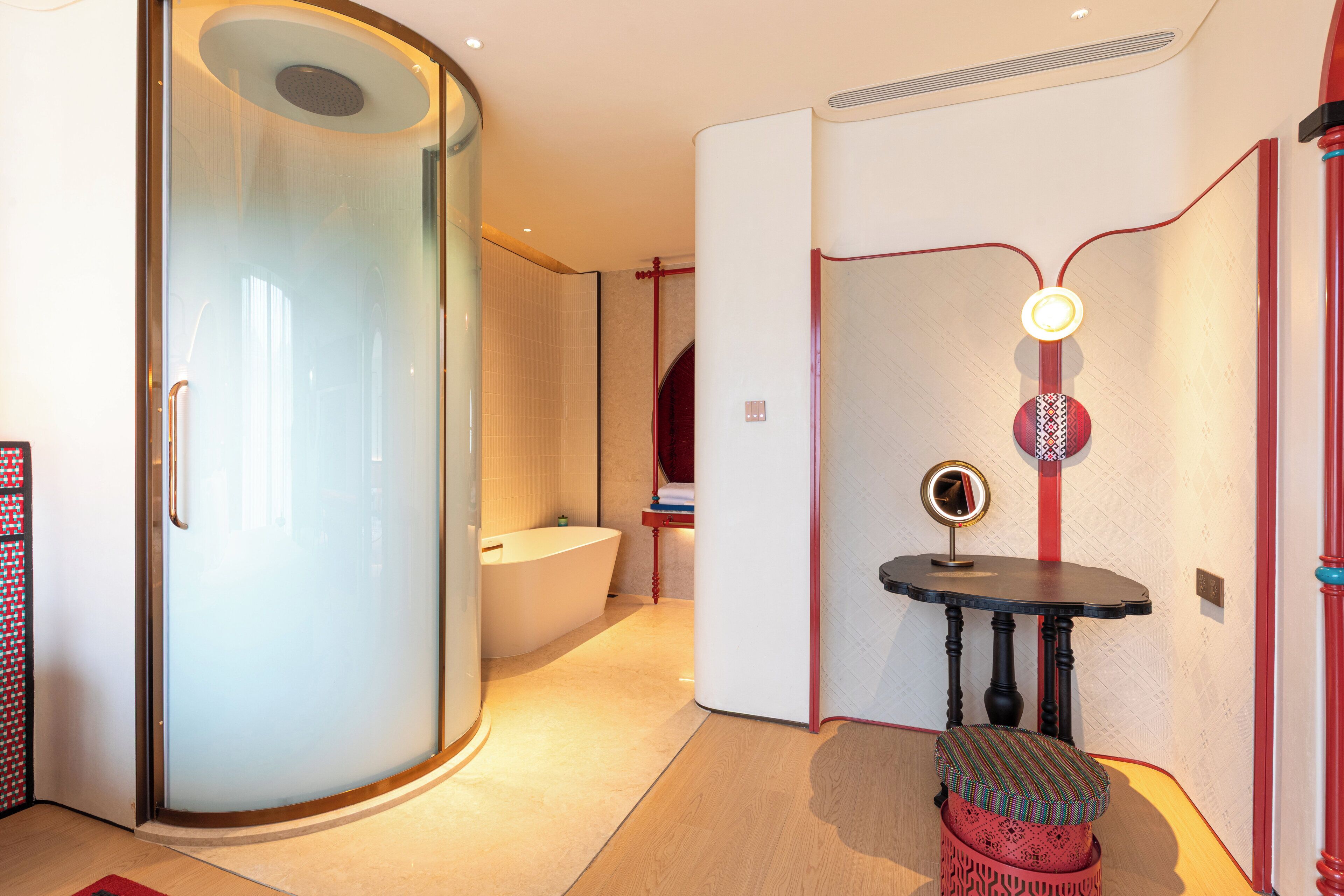 A modern bathroom with a glass shower enclosure, a freestanding bathtub, and a vanity with a mirror.