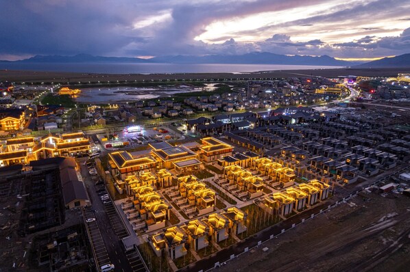 An aerial view of a residential area with multiple buildings, roads, and a body of water in the background.