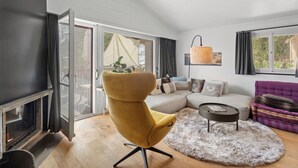 A living room with a sofa, yellow chair, and a fireplace.