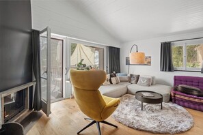 A living room with a sofa, yellow chair, and a fireplace.