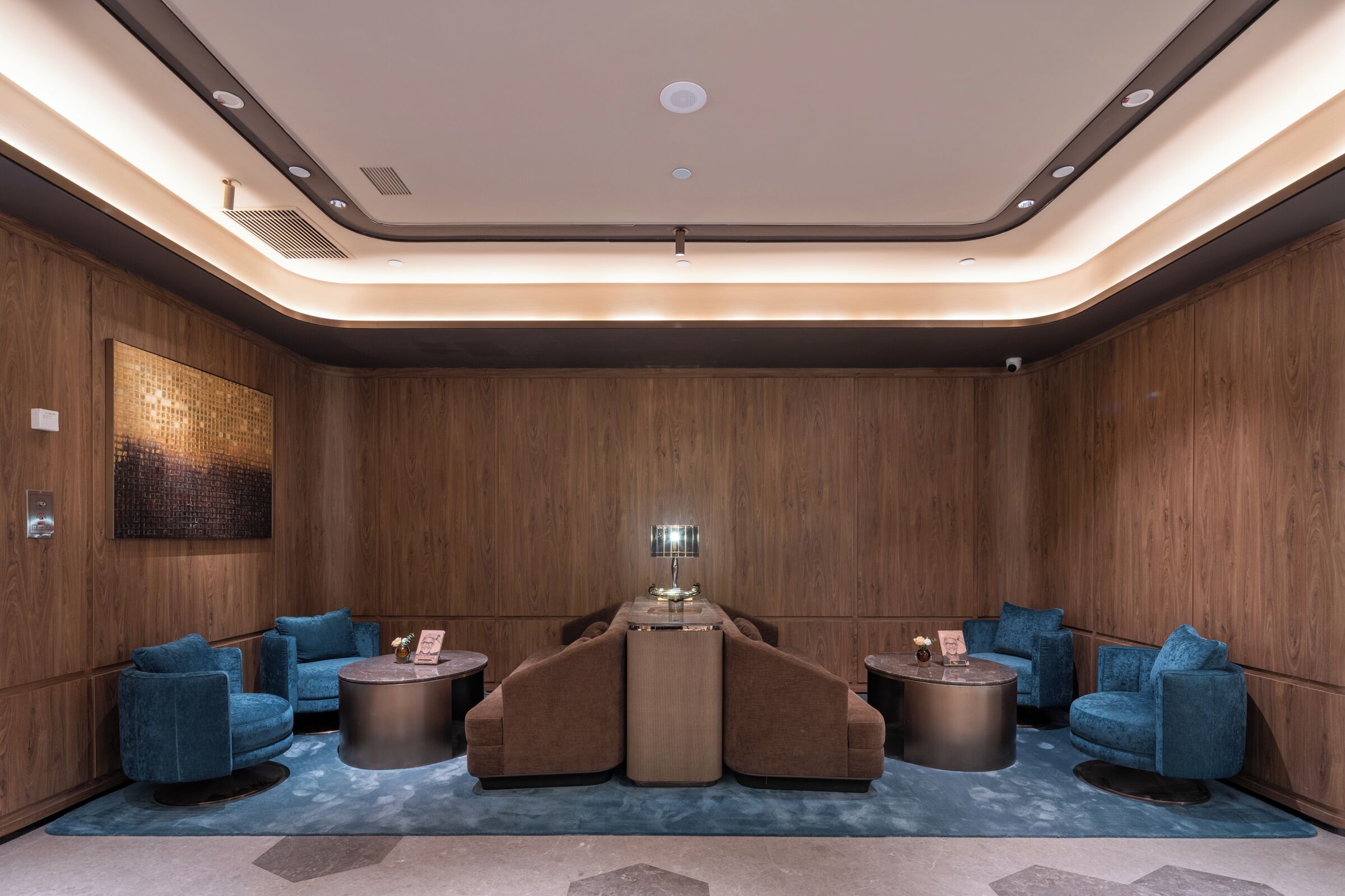 A modern lounge with a central sofa, two side sofas, and a coffee table.