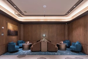 A modern lounge with a central sofa, two side sofas, and a coffee table.