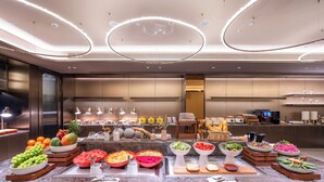 A buffet with various food items and a modern interior design.