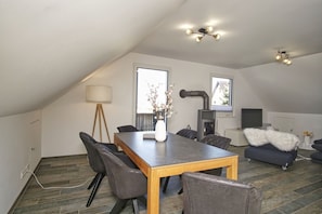 A modern loft with a dining area, seating, and a fireplace. - House Clemens in the Baltic seaside resort of Thiessow (Thiessow)